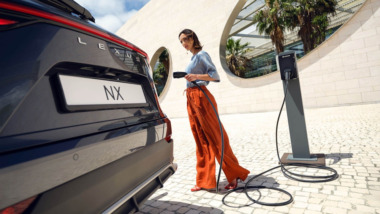 A person plugging a charger into a Lexus NX